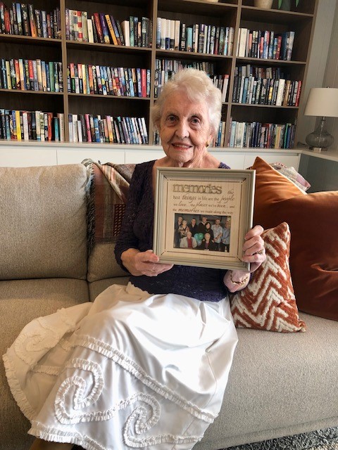 Samford Grove resident Dawn Morton holds a picture frame of her family in the Samford Grove library.
