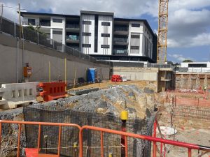 Construction of Brookland's The Banksia underway with orange fences and trucks beginning earthworks on site.