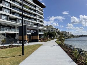 Esperance sign on a modern building is complete with paved boardwalk and canal next to the building.