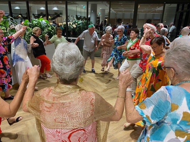 Esperance residents wearing colourful clothes and dancing in a circle at the resident Christmas party.