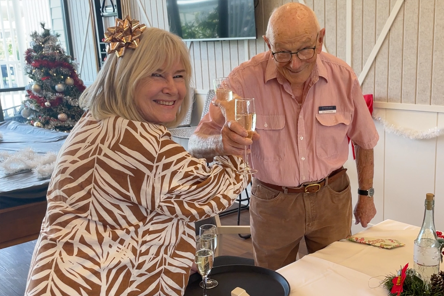 Lady and man enjoy a glass of bubbles at Samford Grove during resident Christmas party.