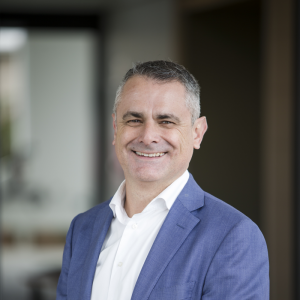 Headshot of Reside CEO and Co-Founder Glen Brown wearing a blue blazer and smiling.